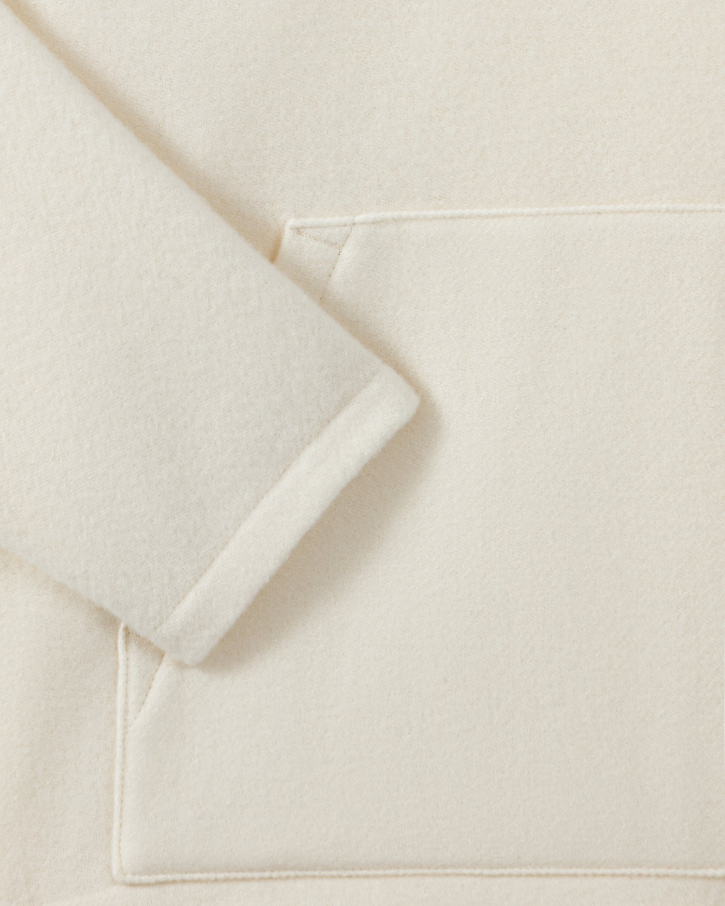 RIER hooded wool fleece in white, close-up of the sleeve and natural wool fleece texture