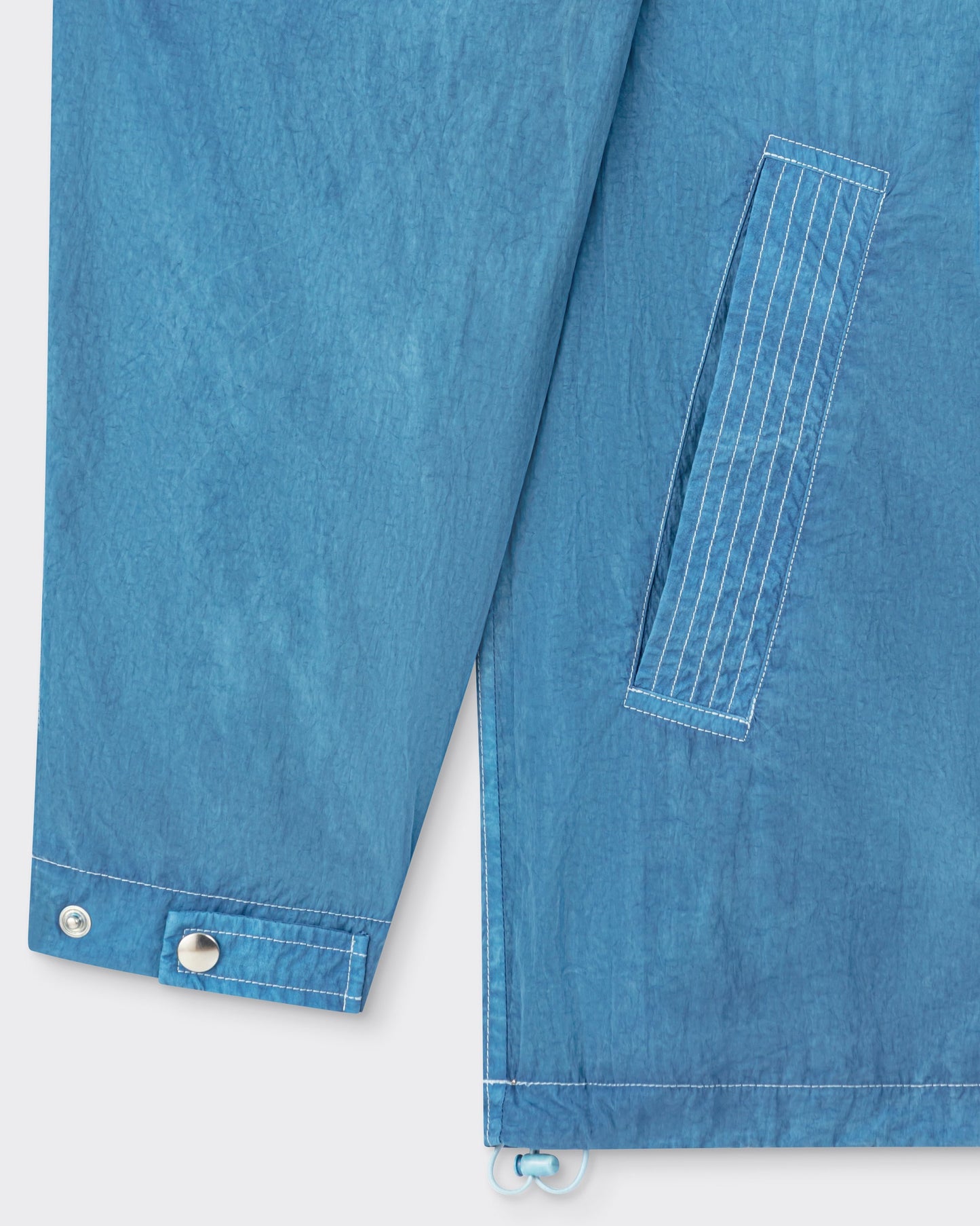 Arpenteur Kaolin nylon jacket in pastel detail of welt pocket and drawstring hem at Beige Habilleur Paris