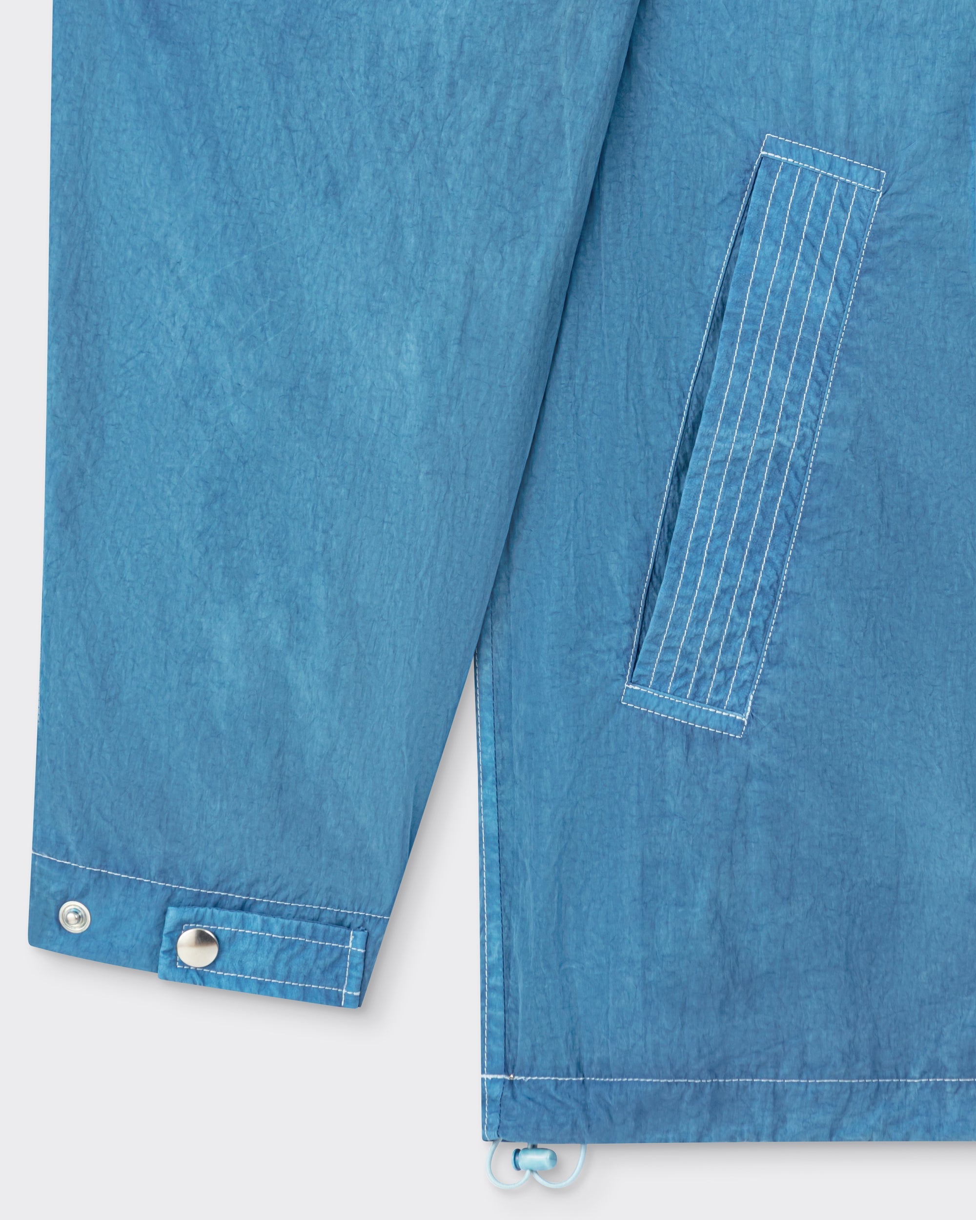 Arpenteur Kaolin nylon jacket in pastel detail of welt pocket and drawstring hem at Beige Habilleur Paris