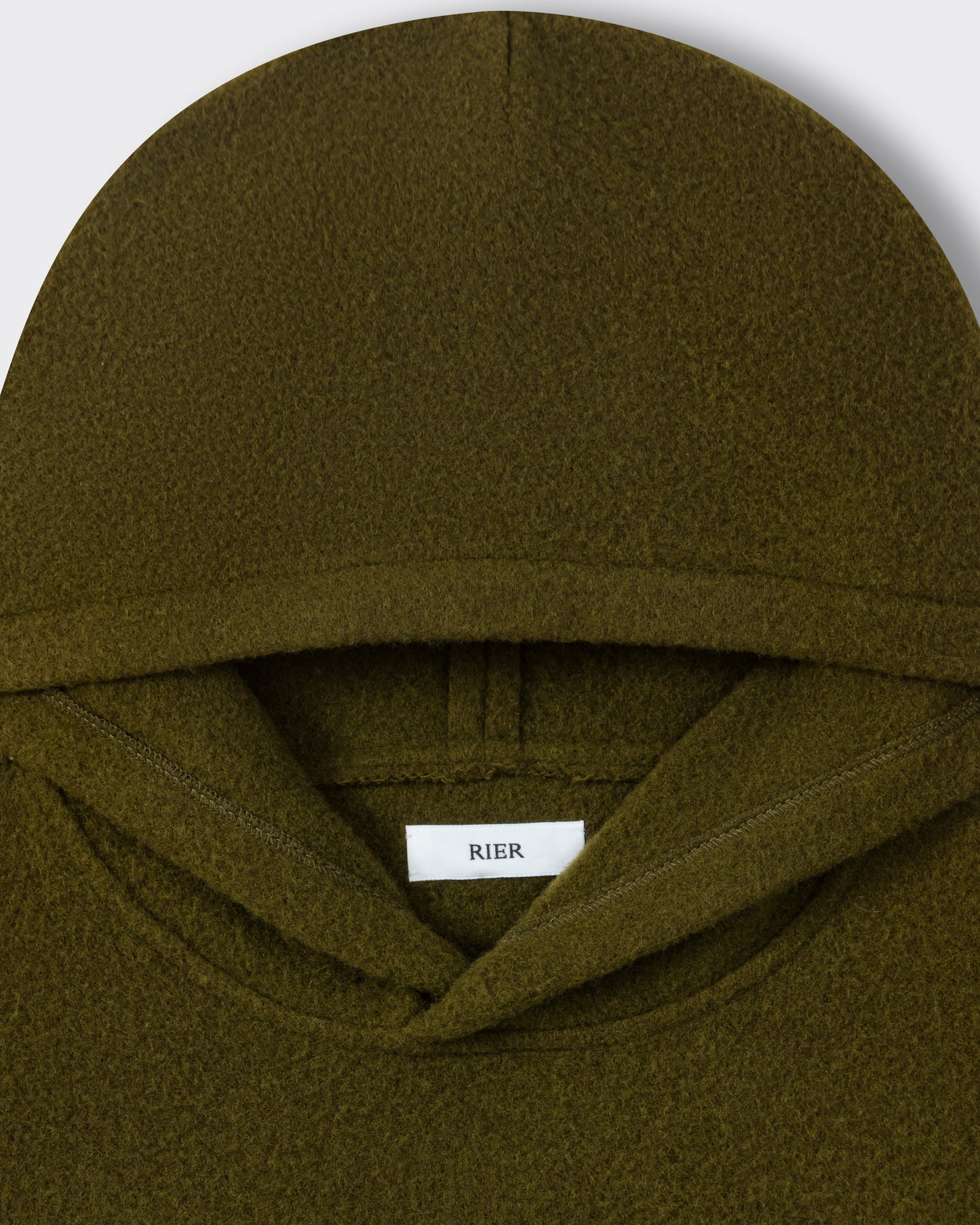 RIER hooded wool fleece in Soil olive green, close-up of the hood and woven label