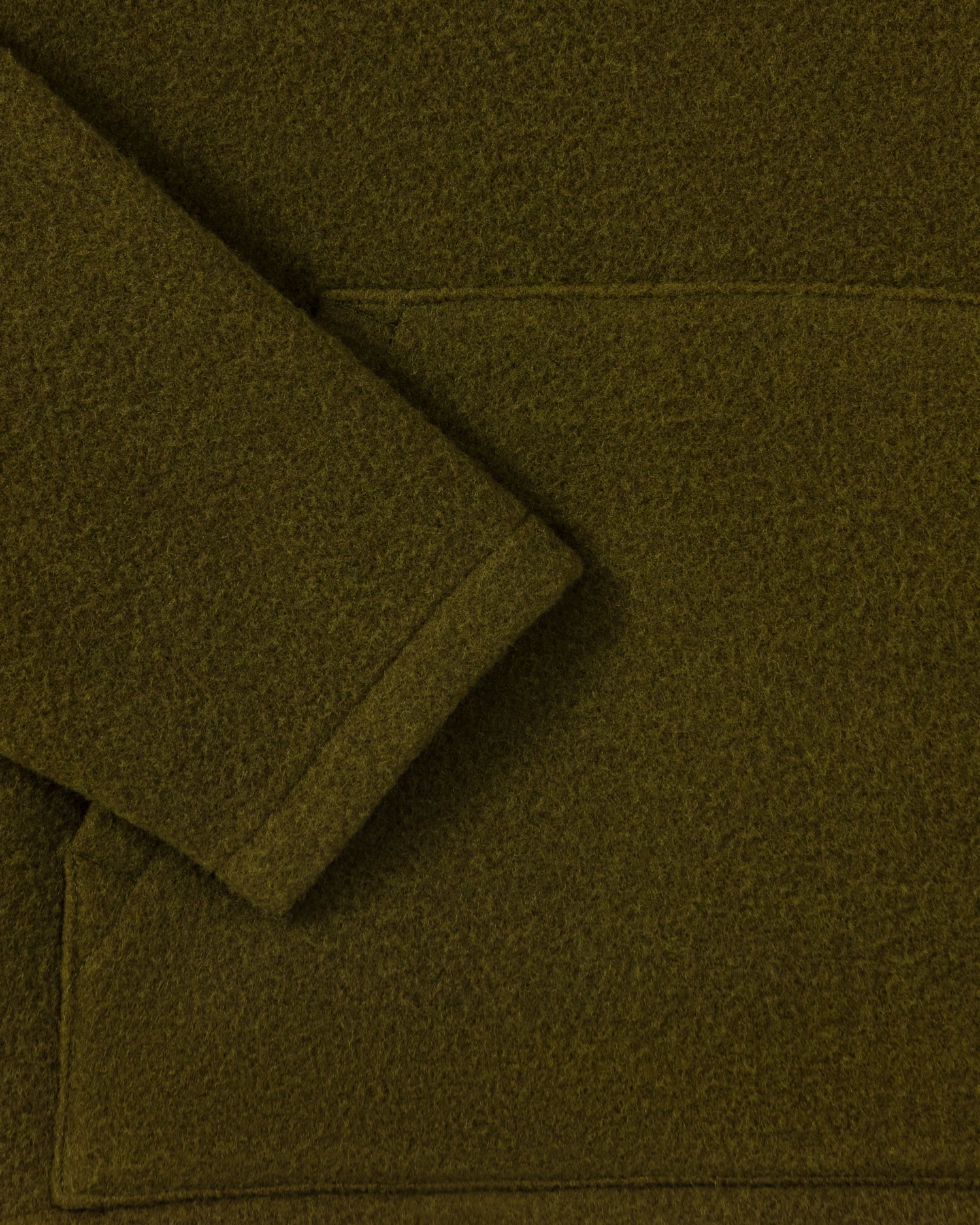 RIER hooded wool fleece in Soil olive green, close-up of the sleeve and natural wool fleece texture
