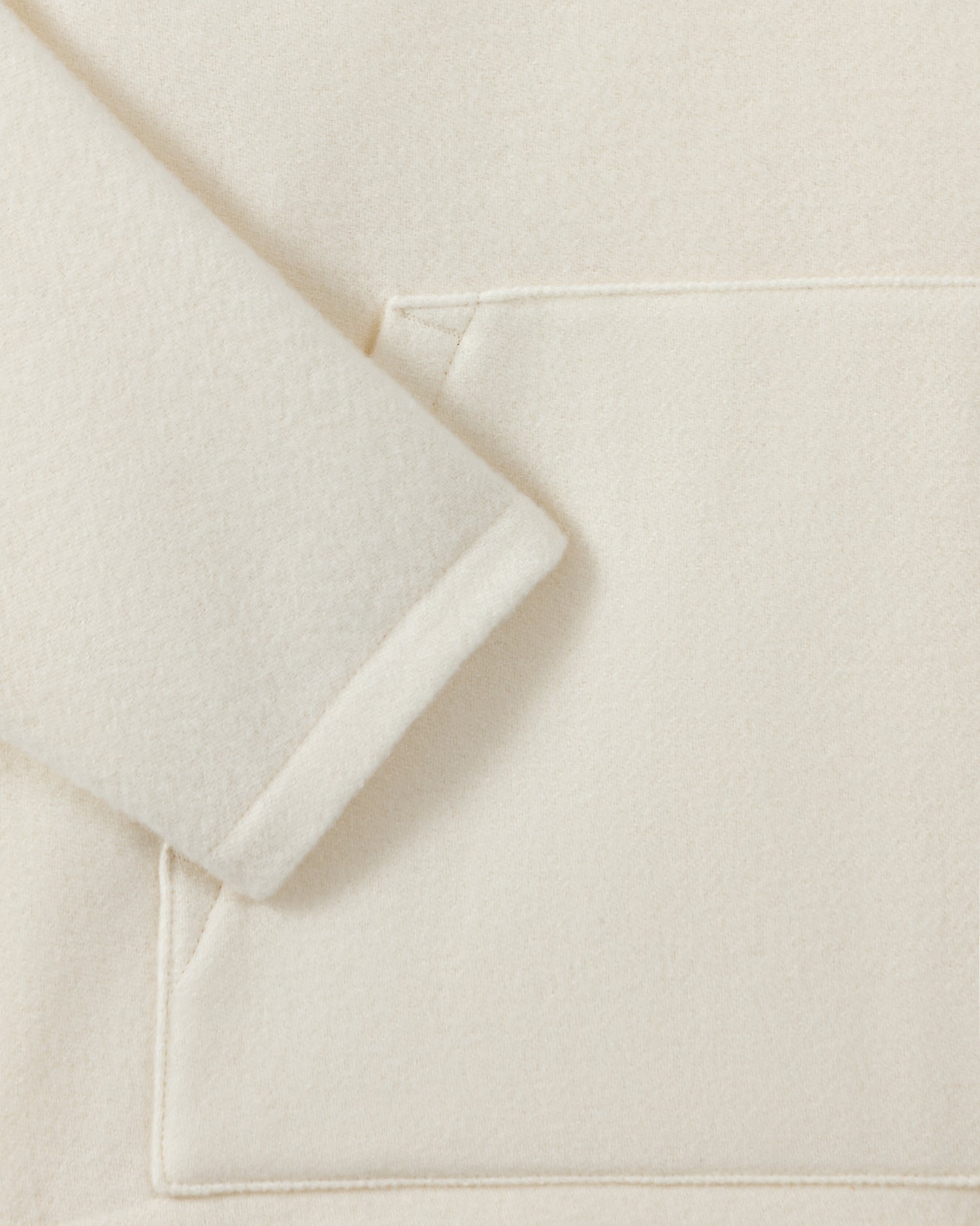 RIER hooded wool fleece in white, close-up of the sleeve and natural wool fleece texture