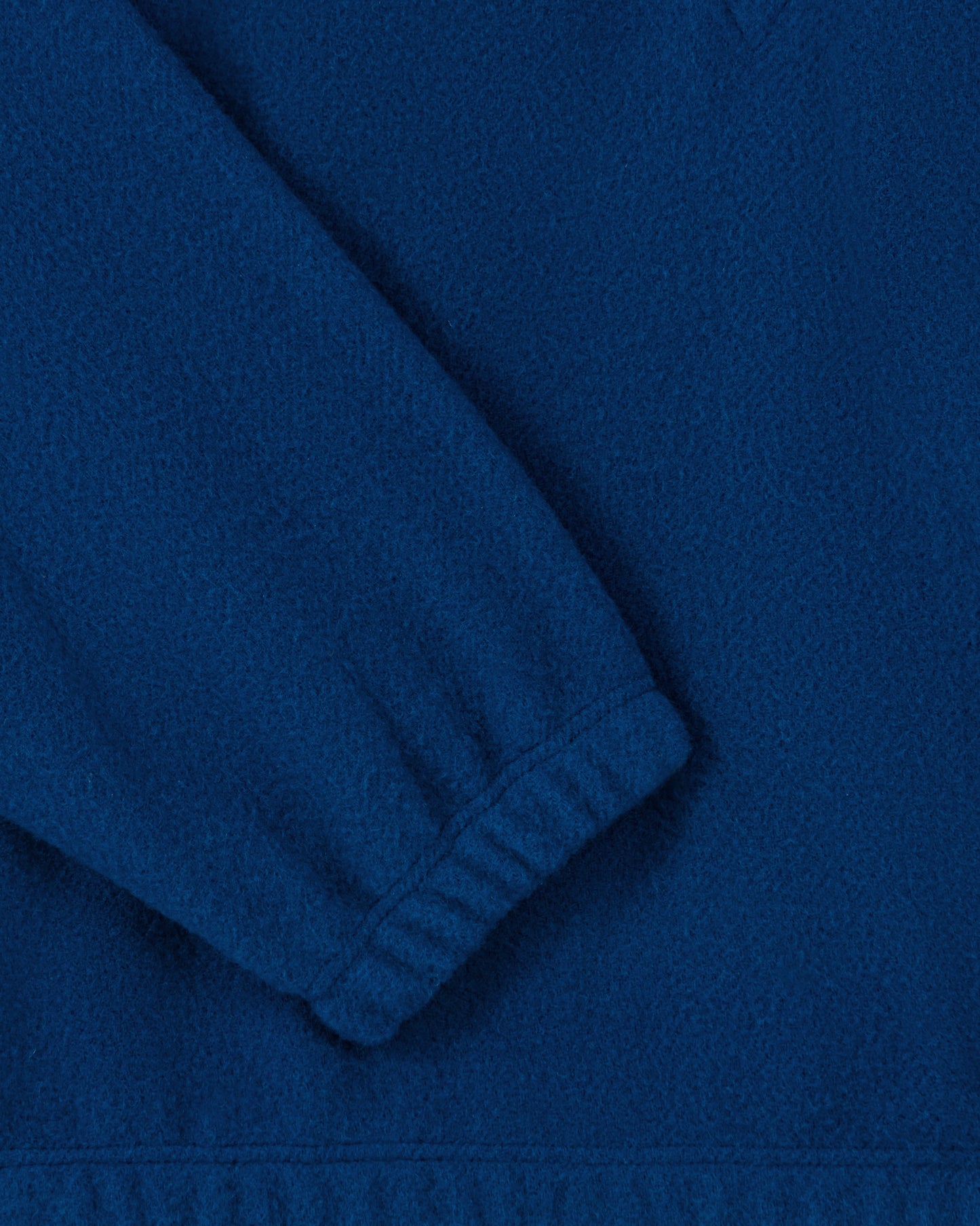RIER half zip wool fleece in indigo blue, close-up of the elasticated cuff and natural wool fleece texture