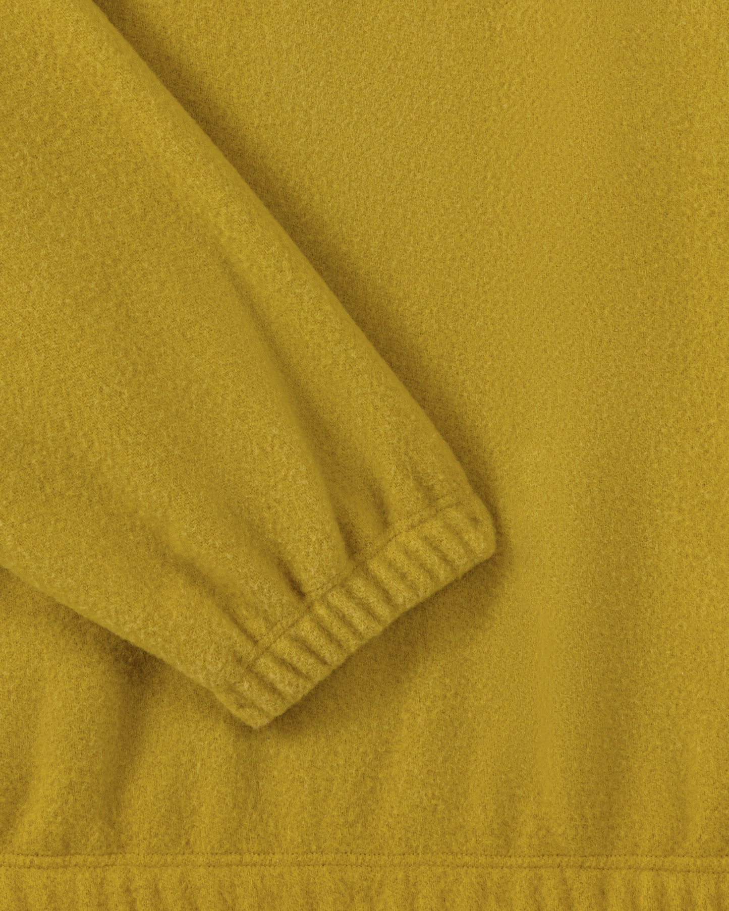RIER half zip wool fleece in Wax mustard yellow, close-up of the elasticated cuff and natural wool fleece texture