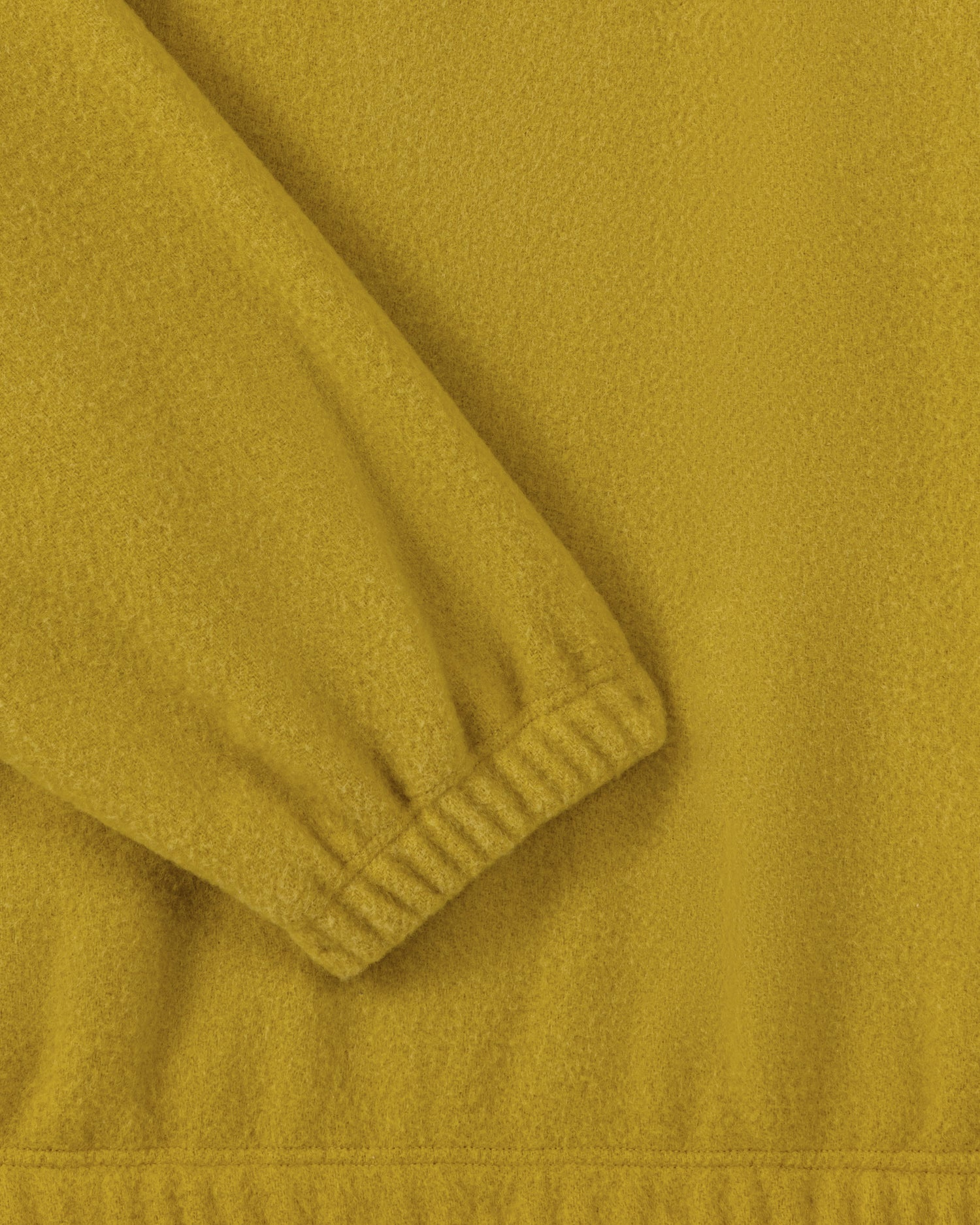 RIER half zip wool fleece in Wax mustard yellow, close-up of the elasticated cuff and natural wool fleece texture