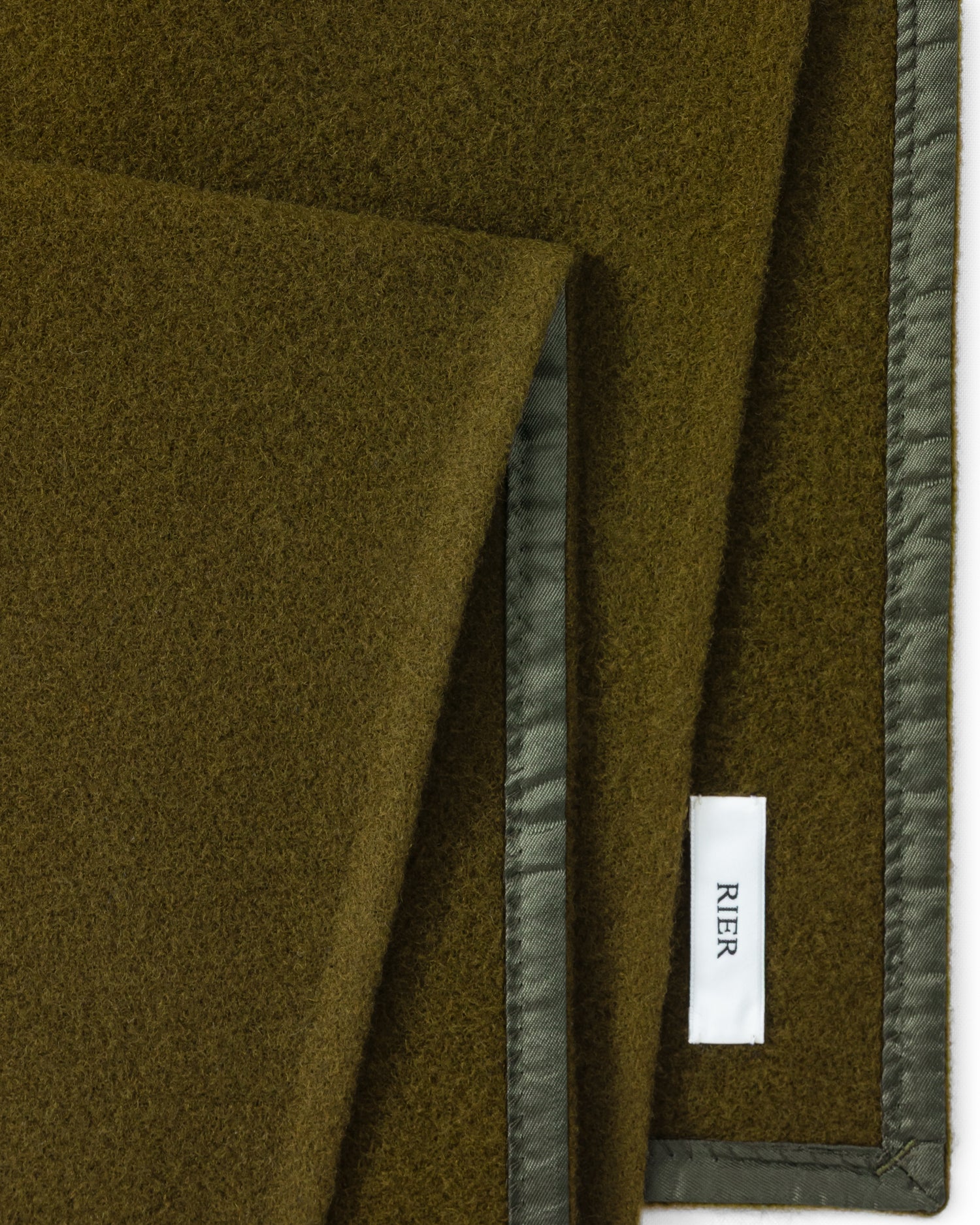 RIER wool fleece scarf in Soil olive green, close-up of the finished edge and woven label